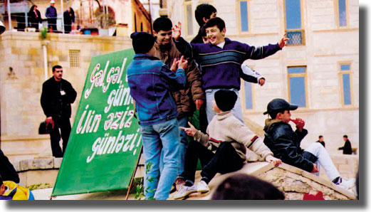 Boys dancing in the streets in Baku. The Novruz banner reads "Come, come the dearest  days of the year"  Jeff Cornish
